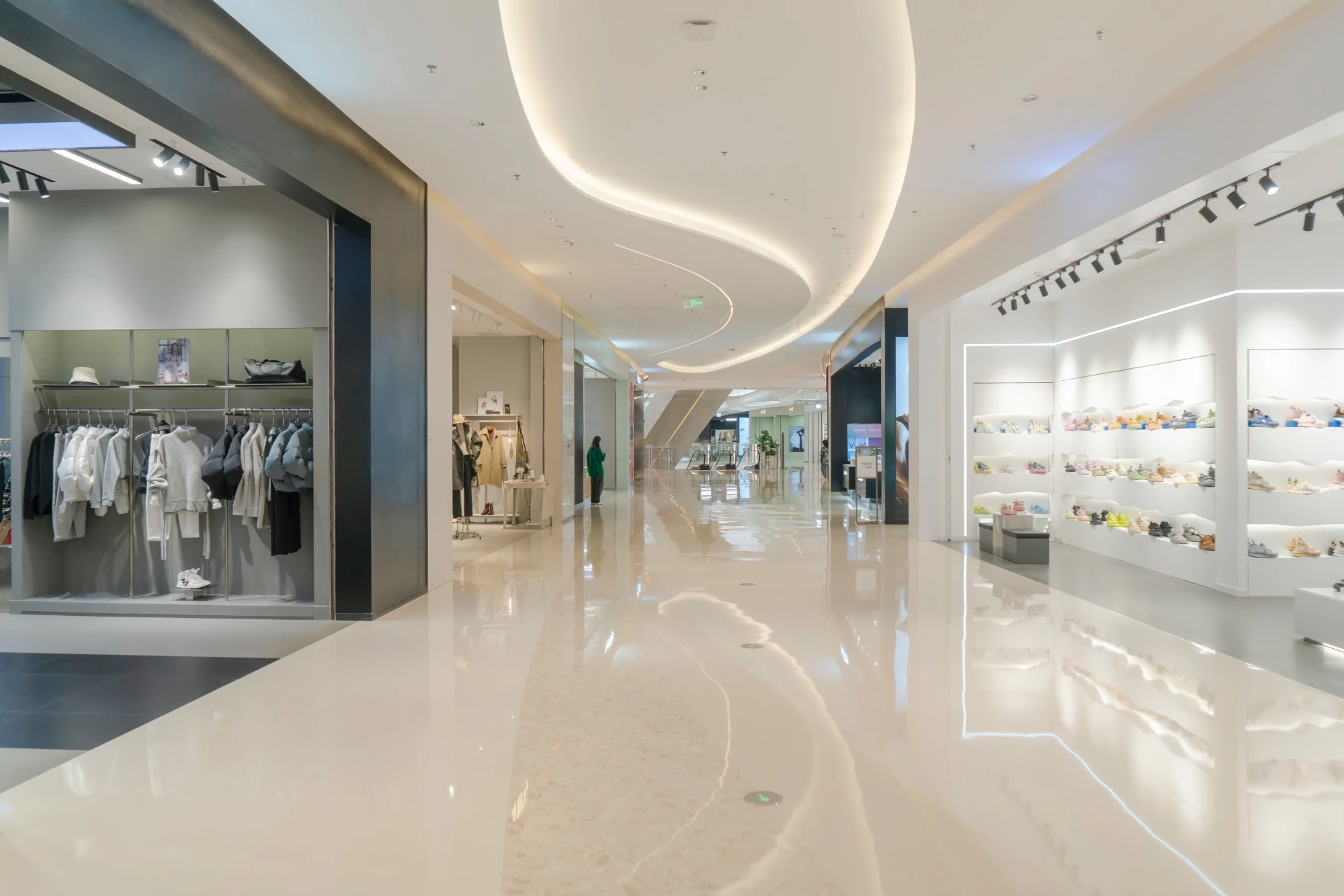 Interior shopping mall corridor with clothing and footwear stores
