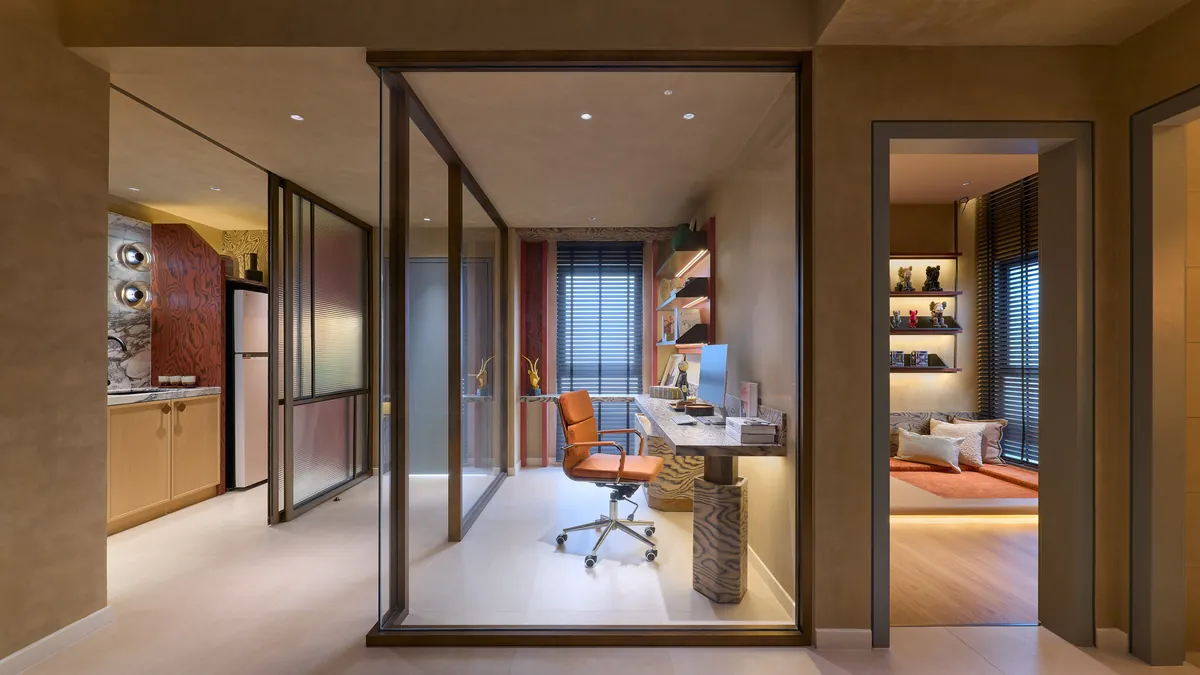 Type A study nook behind a glazed partition, an orange task chair at the desk